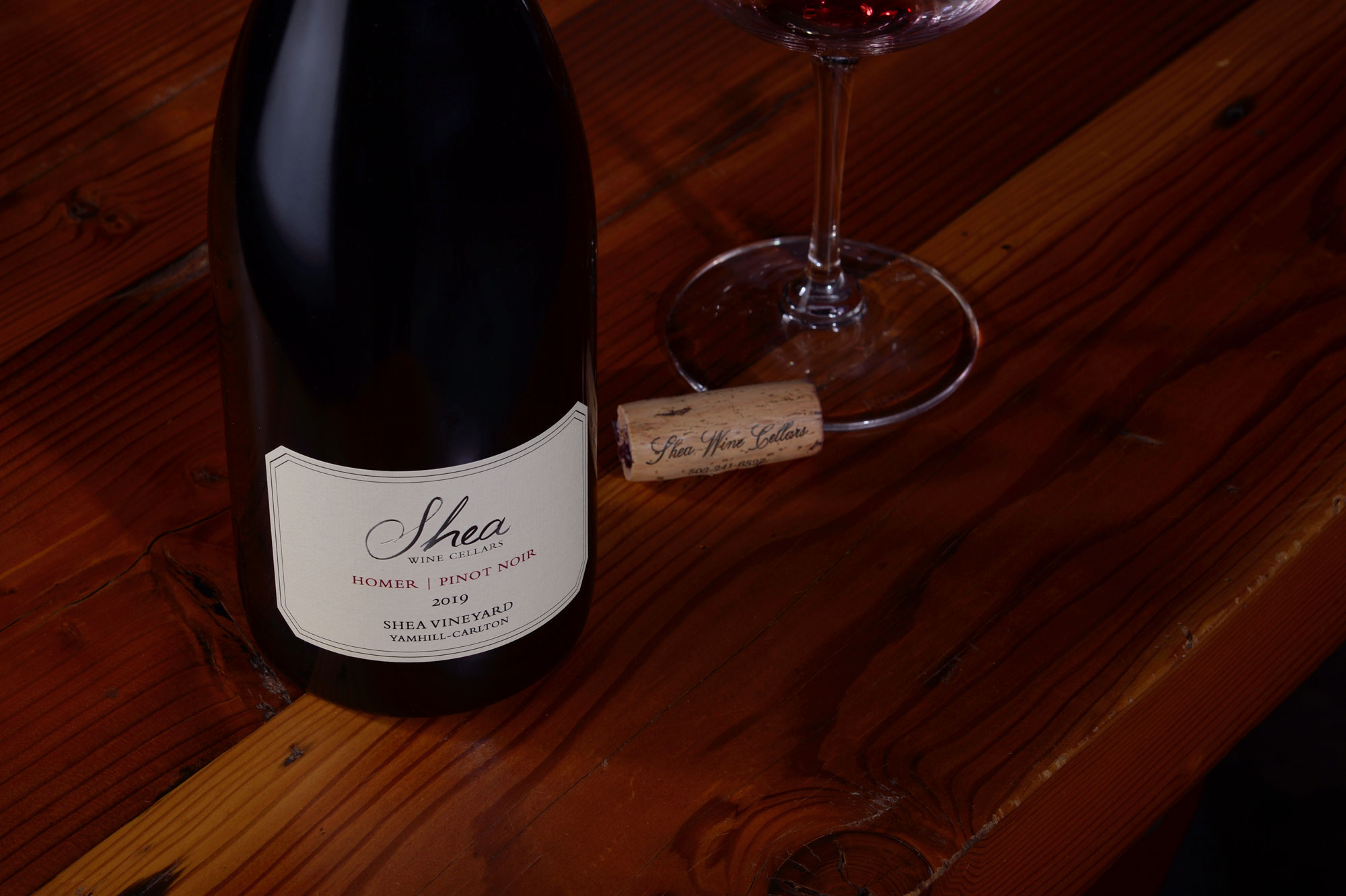 Bottle of Shea Wine Cellars 2019 Homer Pinot Noir, a cork, and a glass